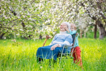 Little boy playing peekaboo with his great grandmother