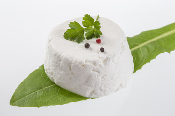 goat cheese on white background with fresh herbs