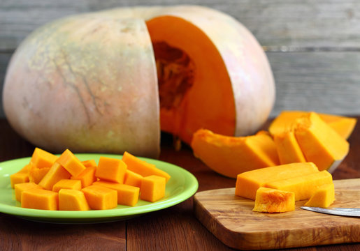 Slices of pumpkin on a wooden table.