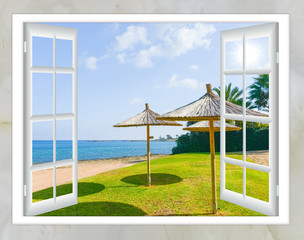window the door with the key views of the sea beach with an umbrella and a lawn green