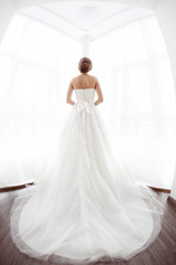 Fototapeta na wymiar Brides beauty. Young woman in wedding dress indoors