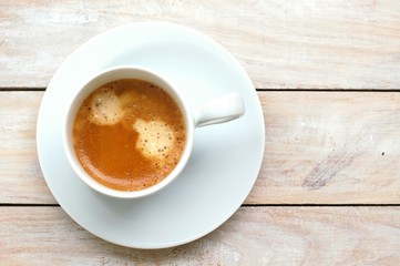 Espresso in the cup on the wooden background