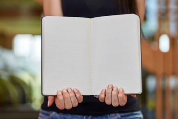 Young caucasian woman holding and showing book