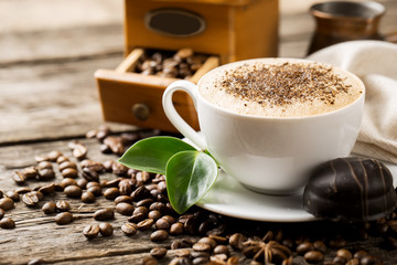 hot coffee and coffee beans on the background of coffee grinders
