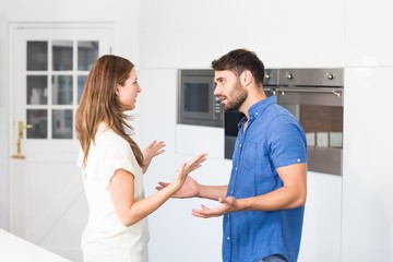 Couple arguing while standing in kitchen 