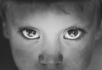 Naklejka premium Little boy's eyes close up with a tear