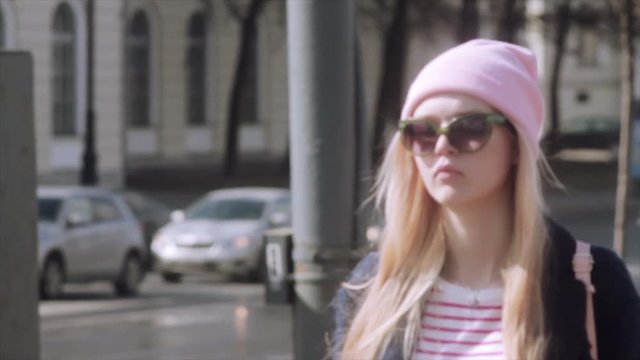 Pretty young girl is walking on a beautiful sunny streets. Slow motion