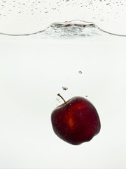 Fototapeta na wymiar falling red apple on the water
