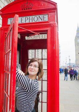 young beautiful girl student in a phone booth in London England