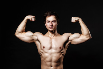 Fototapeta na wymiar Handsome athletic man. Strong bodybuilder with six pack, perfect abs, shoulders, biceps, triceps and chest. Great fitness body. Ideal for commercial 