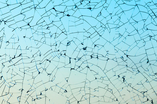 Broken glass with cracks over blue background