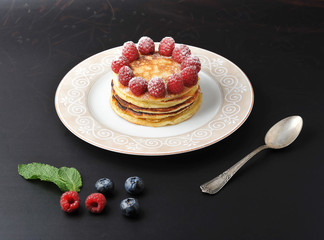 round cake of several layers with raspberries