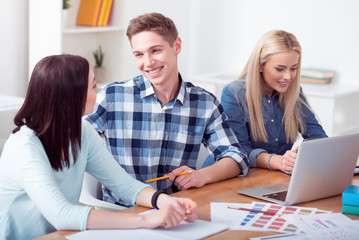 Fototapeta premium Young pleasant students sitting at the table