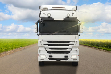 front of a truck driving with blue cloudy sky