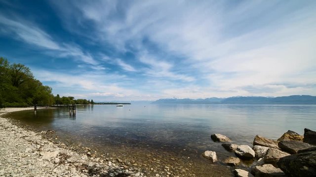 Timelapse of passing clouds over a rocky beach on lake Geneva near the city of Rolle, canton of Vaud, Switzerland