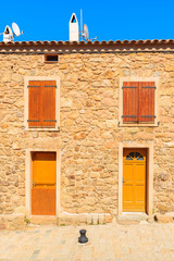 A stone facade of typical French house in Piana village, Corsica island, France