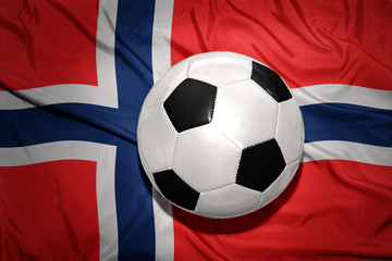 Naklejka premium black and white football ball on the national flag of norway