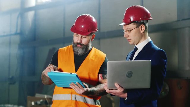 Advanced technology at the construction site - the architect and builder is working with the device - laptop and tablet