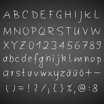 Alphabet, Zahlen, Zeichen, sonderzeichen in weißer Kreideschrift auf einer schwarzen Tafel.