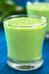 Erfrischender hausgemachter grüner Smoothie aus Avocado, Limone und Joghurt in einem Glas (Selektiver Fokus, Fokus auf die Vorderkante des Glasrandes)