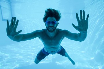 Man swimming underwater at resort
