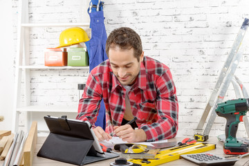smiling young man using the tablet for DIY