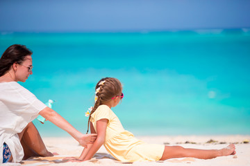 Fototapeta premium Mother applying sun protection cream to her daughter at tropical beach