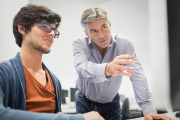 Computer teacher assisting a student