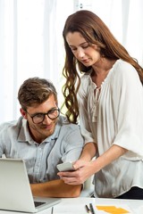 Man and woman using mobile phone in office