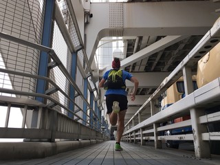 Man running over city bridge