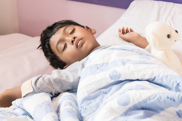 Obraz na płótnie Canvas Cute little boy sleep on the bed in room