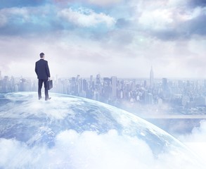 Composite image of businessman standing with his briefcase