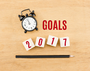 Goals 2017 year on wood cube with pencil and clock top view on w