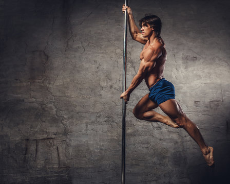 Shirtless man pole dancing.