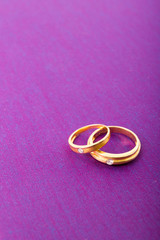 Gold ring with diamond on purple background