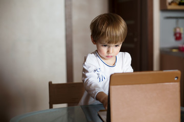 Serious Kid Little girl using tablet pc at home. Technology childhood, learning and communication with internet