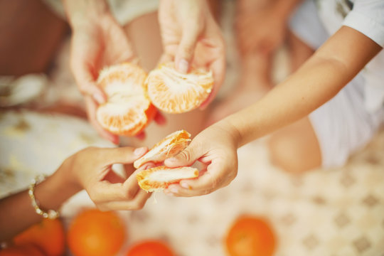 Orange in people hands. Family concept. Eating together, organic food diet