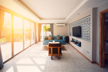 Villa interior living room. Sunlight through big window, terrace