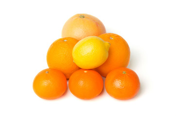 A heap of mixed citrus fruit including lemon, grapefruit, oranges and mandarines isolated on a white background