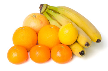 Mixed fruit including lemon, grapefruit, oranges, bananas and mandarines isolated on a white background