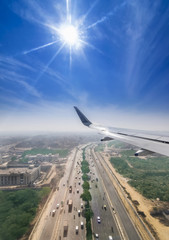 View through the window of a passenger plane flying above Delhi