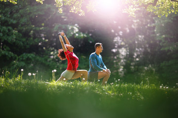 In the midst of nature's tranquility, a young couple takes a moment to stretch after jogging, embracing the serene ambiance that surrounds them.