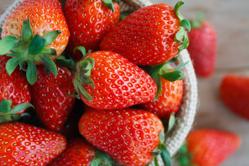 strawberries in small sack on wooden table background