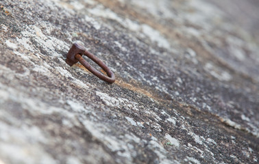 Metal ring climbing equipment at stone cliff