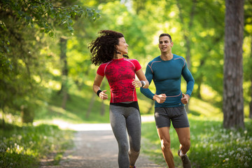 Amidst nature's beauty, a young couple enjoys a refreshing jogging, savoring the fresh air and beautiful spring surroundings.