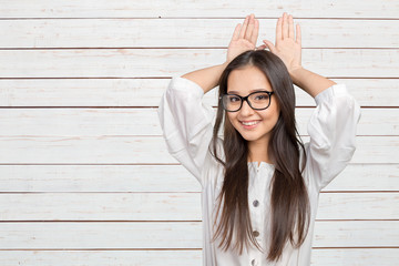 Happy woman showing rabbit ears with her palms