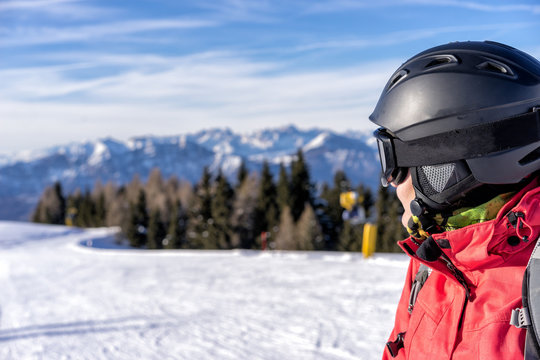 Female skier enjoys view on italien slopes with beautiful mountains in distance. Head detail.