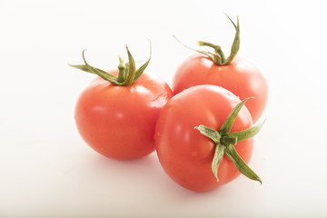 photo of very fresh tomatoes presented on white background