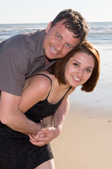 Fototapeta na wymiar Attractive couple cuddling and embracing at the beach,