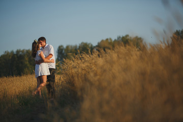 Naklejka na ściany i meble romantic happy couple go on a wheat field.